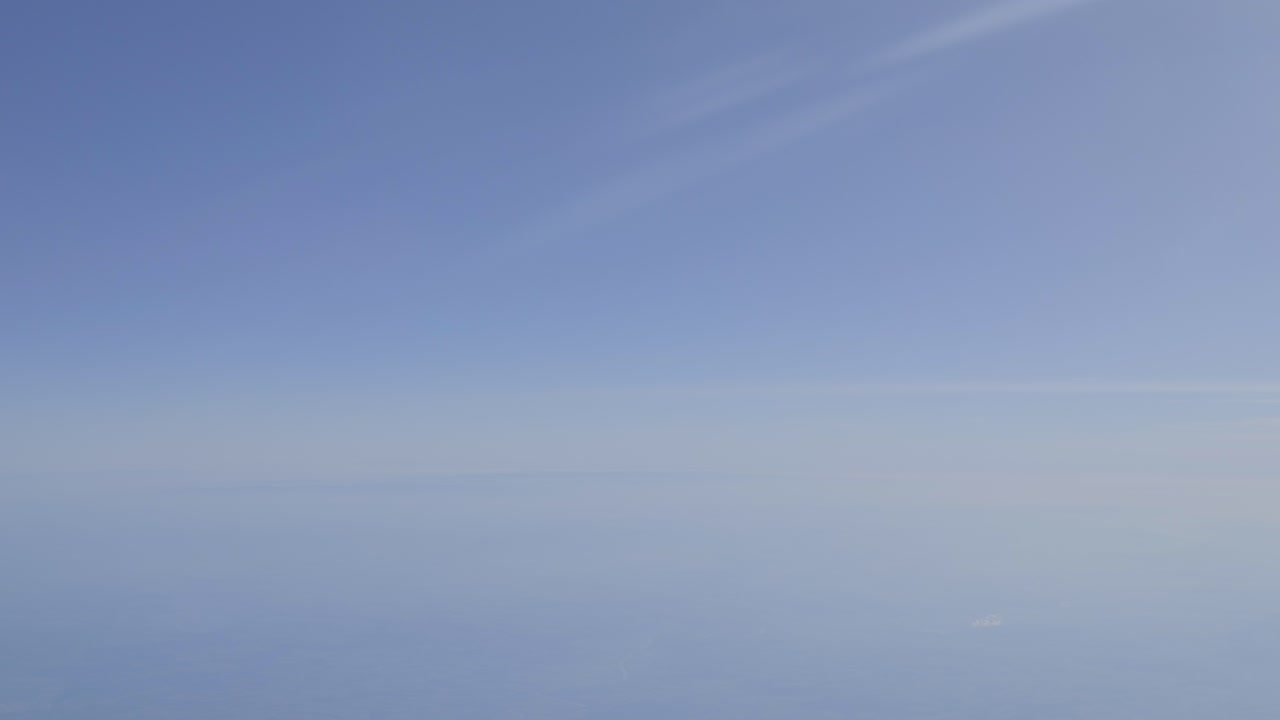 Clear blue sky with soft gradient, peaceful atmosphere, aerial shot from above the clouds