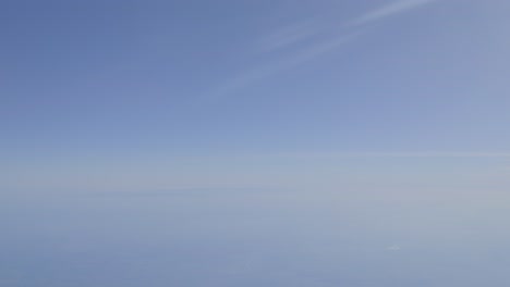 clear blue sky with soft gradient, peaceful atmosphere, aerial shot from above the clouds