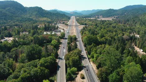 a drone flies over the freeway, cutting through the mountains and trees of oregon