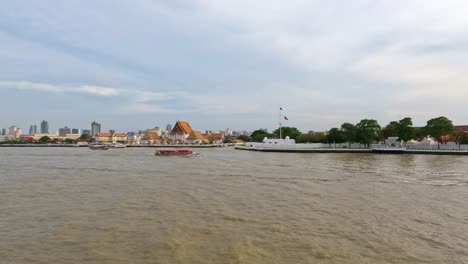 bangkok city skyline with wat kalayanamit woramahawihan temple by the chao phraya river waterfront - realtime