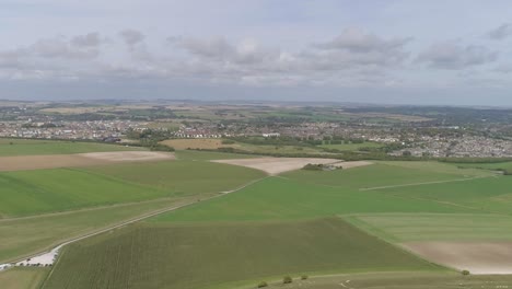 Seguimiento-Aéreo-Al-Norte-Del-Castillo-De-La-Doncella,-Las-Ciudades-De-Dorchester-Y-Poundbury-Son-Visibles-Al-Fondo