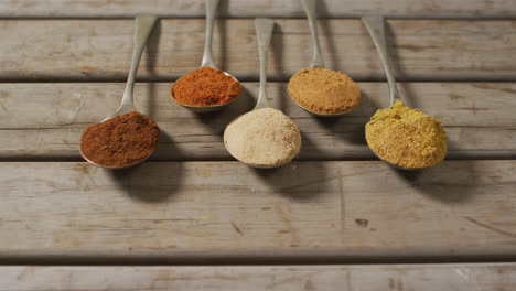 video of spoons with diverse seasonings lying on wooden surface