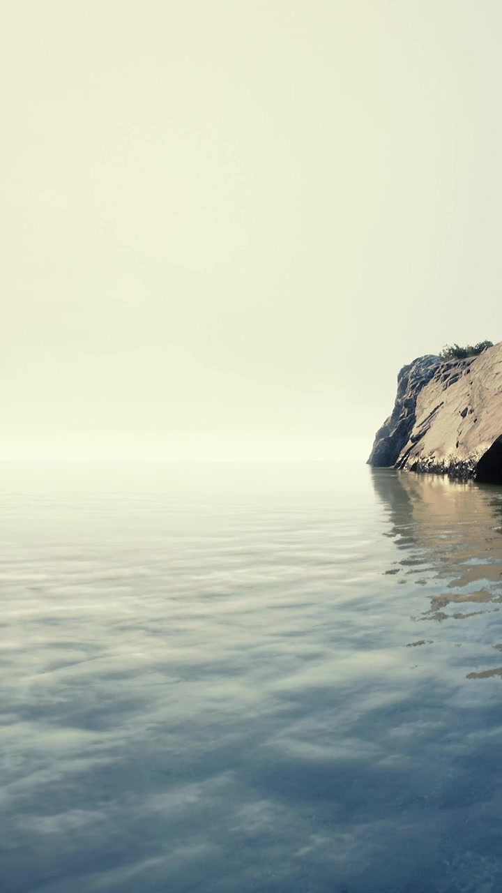 Quiet waters meet the rocky shore in a distant land during daylight hours