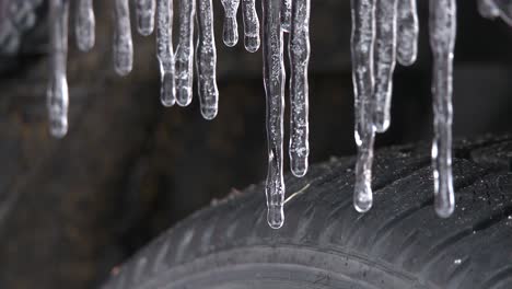 Close-up-of-melting-icicles-on-car-tire-fender