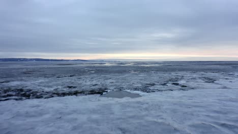 drone flying over the frozen water of the saint-lawrence river in charlevoix