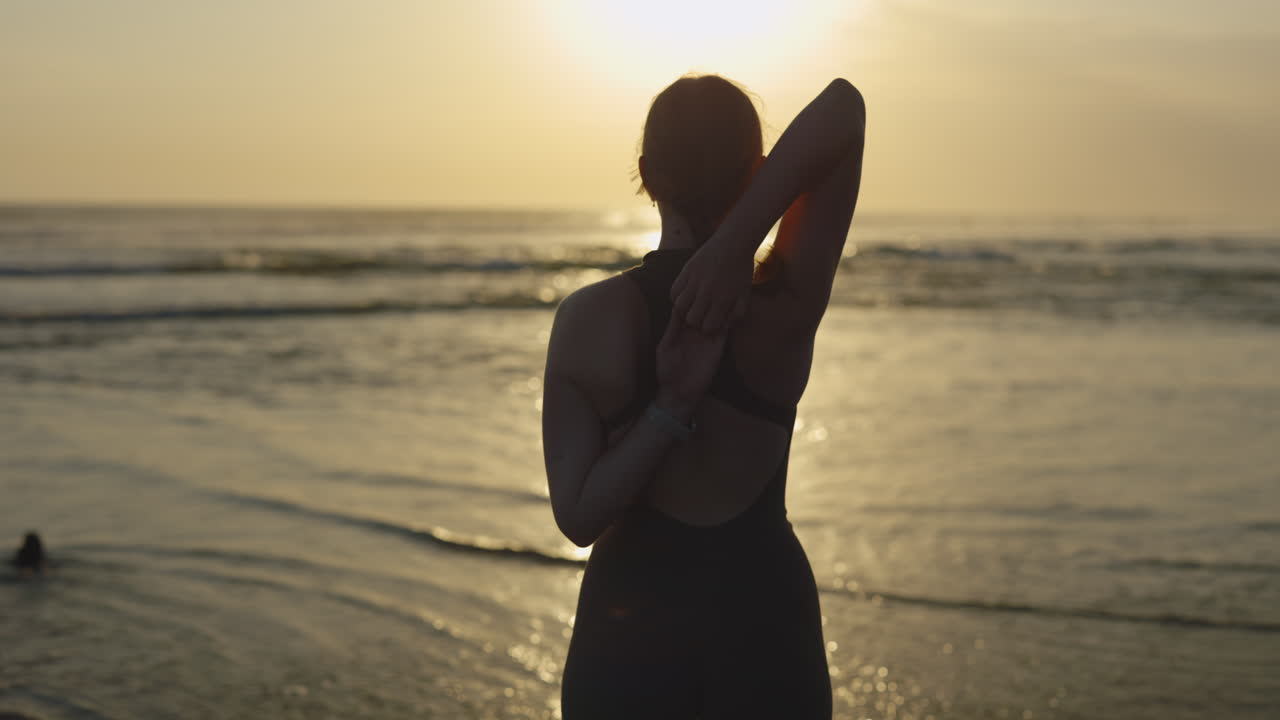 Woman Stretching on the Beach at Sunrise