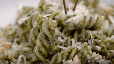 pesto fusilli with grated cheese, close-up, mediterranean