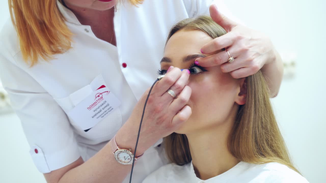 Female ophthalmologist treat patient's eye. Doctor with ophthalmological tool during surgical treatment in clinic.