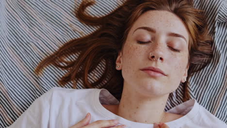 close-up of a young woman with freckles sleeping peacefully