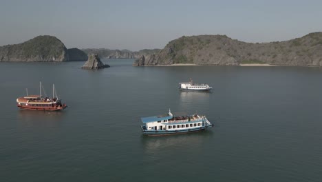 los turistas descansan en la cima de un gran barco turístico que navega en la bahía de ha long, vietnam
