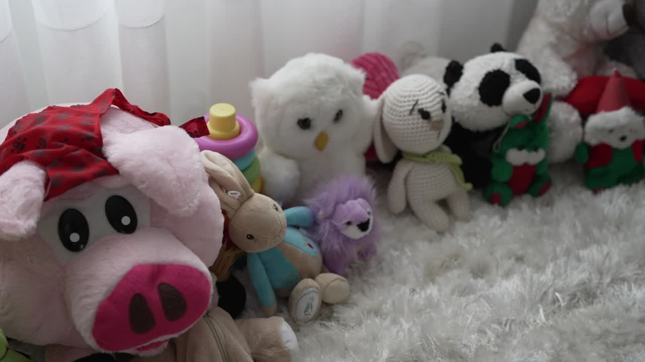 Various plush toys, including a pig, owl, and panda, arranged on a soft white carpet