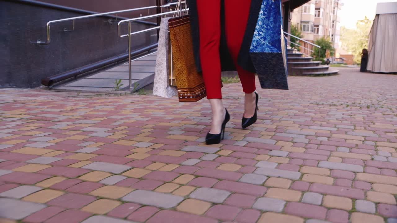 steadicam shot elegante mujer con bolsas de compras caminando por la acera en la imagen se puede ver o