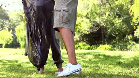 happy volunteers picking up trash in the park