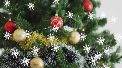 Animation-of-snow-falling-over-christmas-tree-with-baubles