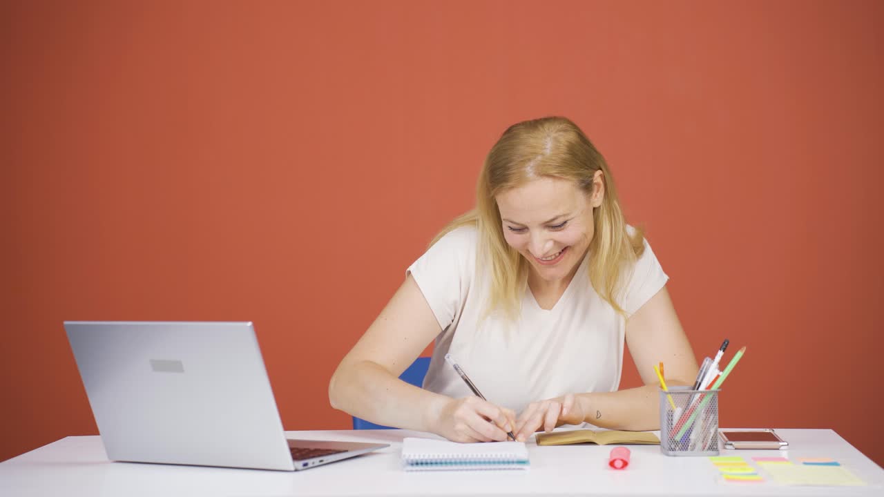 mujer trabajando en una computadora portátil con expresión feliz.