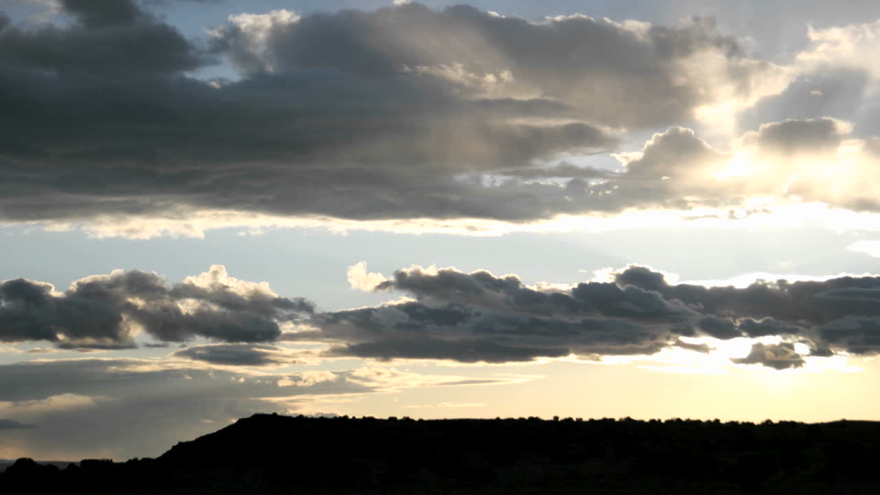 las halas del sol brillan cuando un sol dorado brillante aparece detrás de las nubes grises
