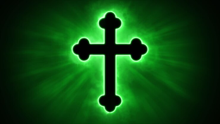 Uplifting and deeply inspiring reveal animation of an ornate and holy green Christian crucifix cross, in a smoky mystical glow and emating shining God rays and light beams, on a black background