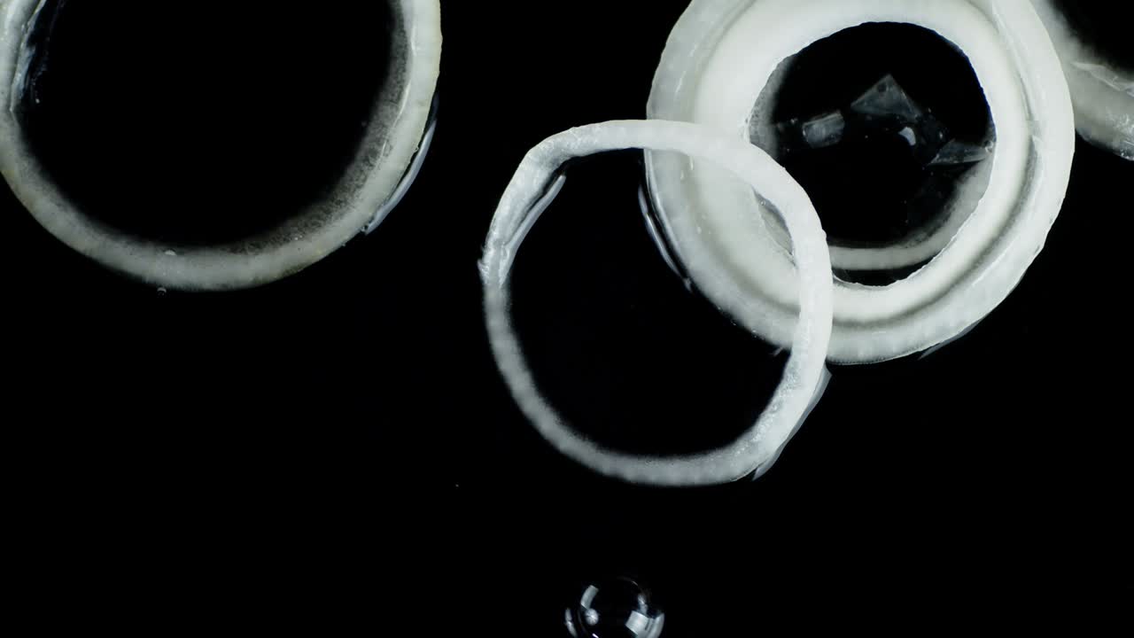 양파 반지는 공기 거품으로 물 위에 굴러갑니다.