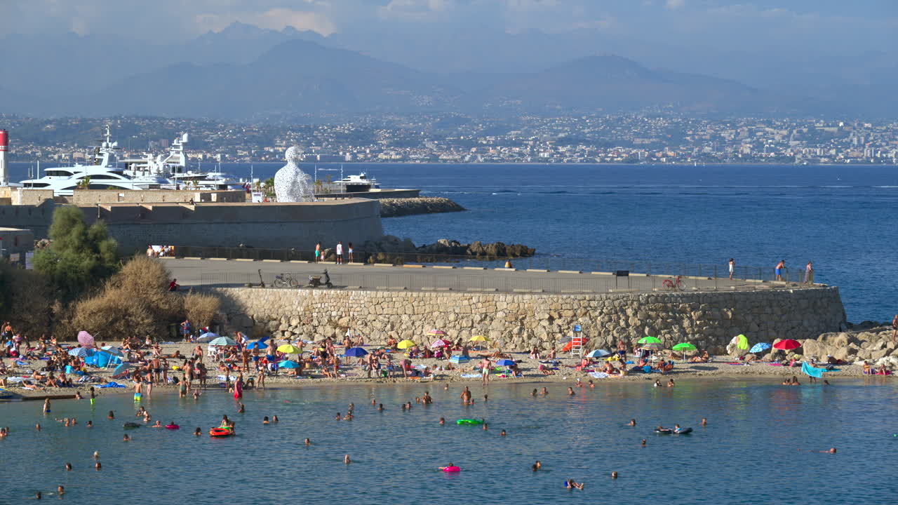 View of people swimming in the sea and relaxing at the beach, Antibes, France