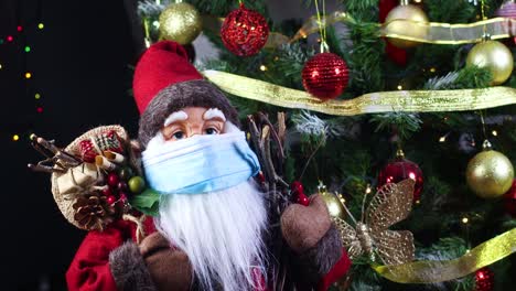 santa claus con máscara facial junto al árbol de navidad