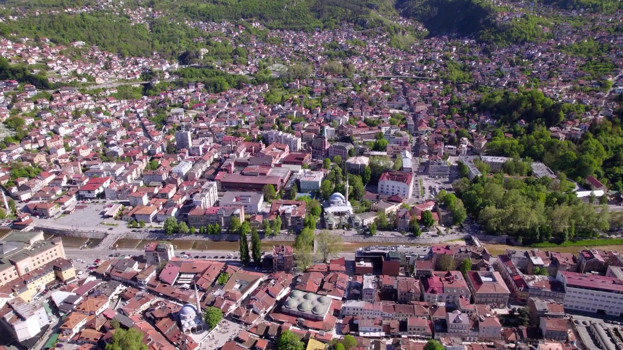 Lennokilla kuvattu panoraamatausta historiallisesta Sarajevon keskustasta tiheästi rakennettujen rinnemaisten kaupunginosien ympäröimänä, ilmakuva, Bosnia ja Hertsegovina.