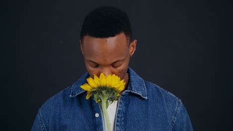 man smelling a sunflower