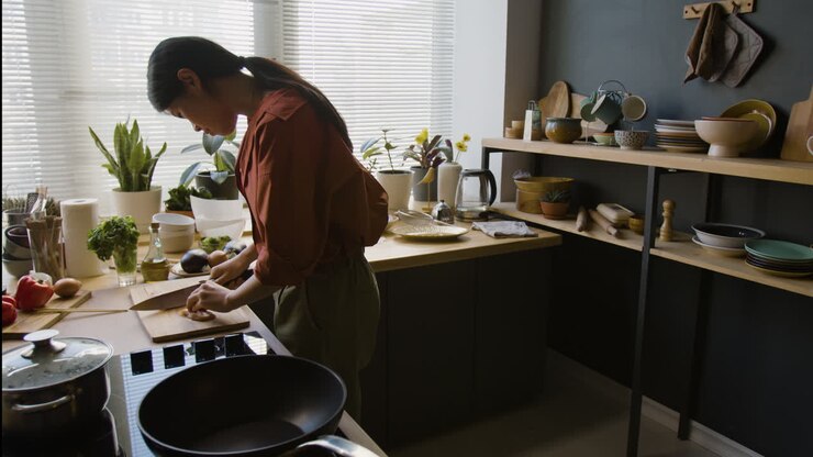 Donna che taglia il pollo in una cucina moderna