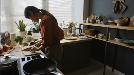 woman chopping chicken in a modern kitchen