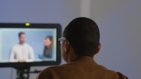 man editing video on monitor