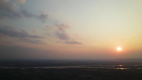 beautiful sunrise over vast landscape with river on a foggy morning. tilt-down