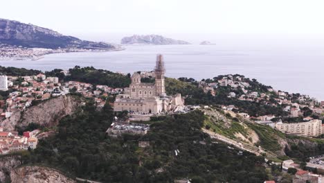 drone view of notre-dame de la garde, mediterranean sea in background