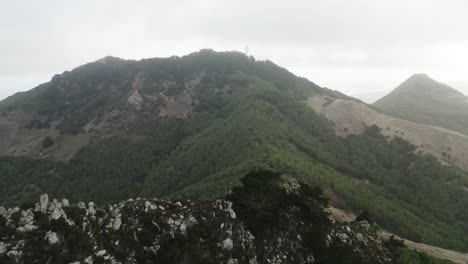 Misty-clouds-at-Castle-Peak-viewpoint-in-Porto-Santo,-aerial