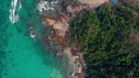 Grüner-Wald-An-Felsen-Und-Sand,-Umgeben-Von-Sauberem-Meer