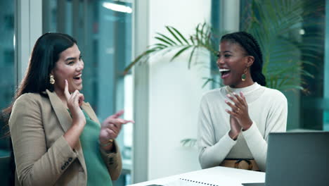 two business women celebrating success in the office
