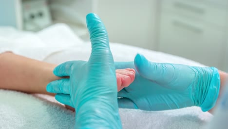 A-stationary-shot-of-a-pedicurist-doing-treatment-on-feet