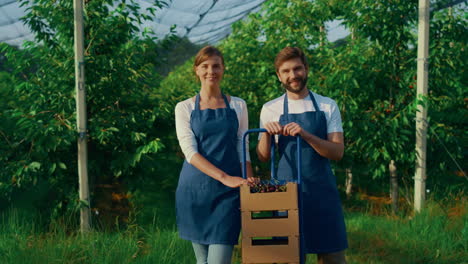 Equipo-De-Agrónomos-Que-Presenta-Una-Canasta-De-Cosecha-De-Cerezas-En-Un-Soleado-Jardín.