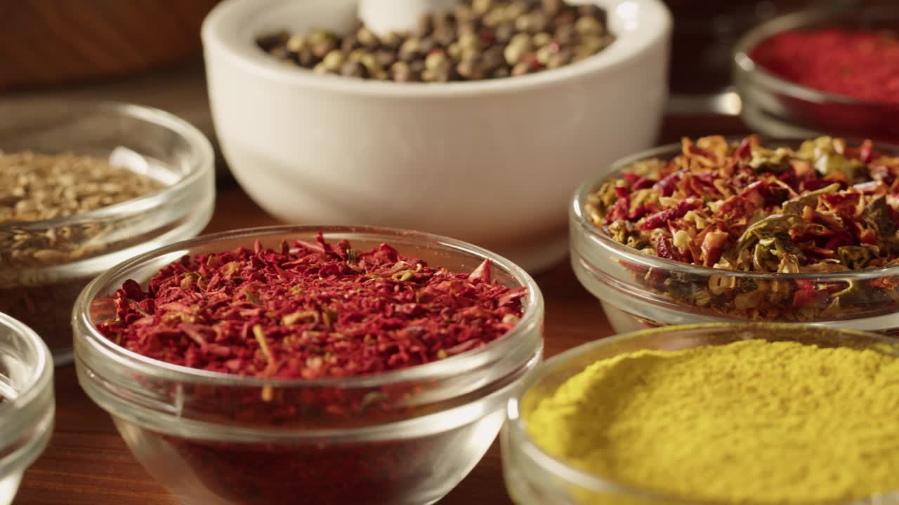 varias especias en cuencos de vidrio de cerca. cultura de oriente medio y árabe. condimentos y sabores. pimienta, cilantro, canela, cúrcuma, pimentón, comino. diferentes tipos de hierbas secas para cocinar.