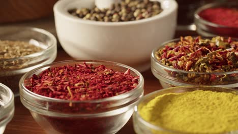 various spices in glass bowls close-up. middle eastern and arabian culture. seasoning and flavors. pepper, coriander, cinnamon, turmeric, paprika, cumin. different kinds of dry herbs for cooking.