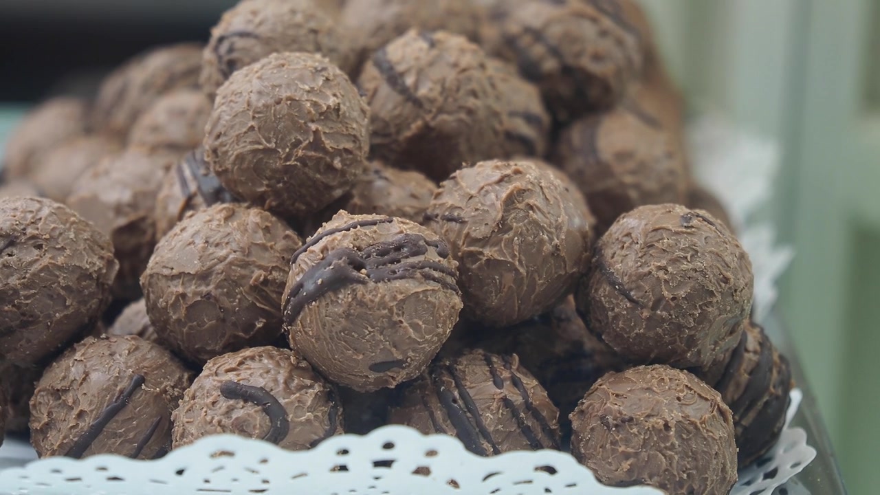 Pila di deliziosi tartufi al cioccolato su un vassoio da esposizione