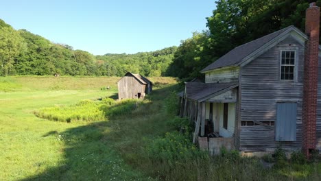 abandoned farmhouse and barn in rural landscape