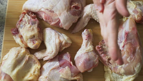 espolvorear sal sobre pollo crudo