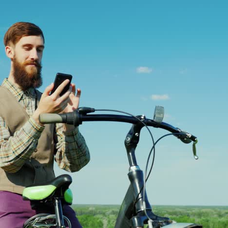 a young man uses a smartphone travels by bicycle 1