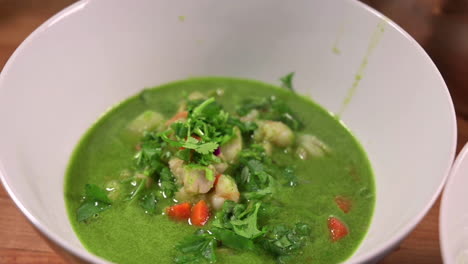 bowl of healthy seafood cilantro soup served on the table - zoom out shot