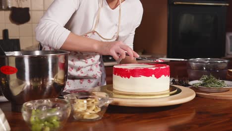 woman decorating a layered cake