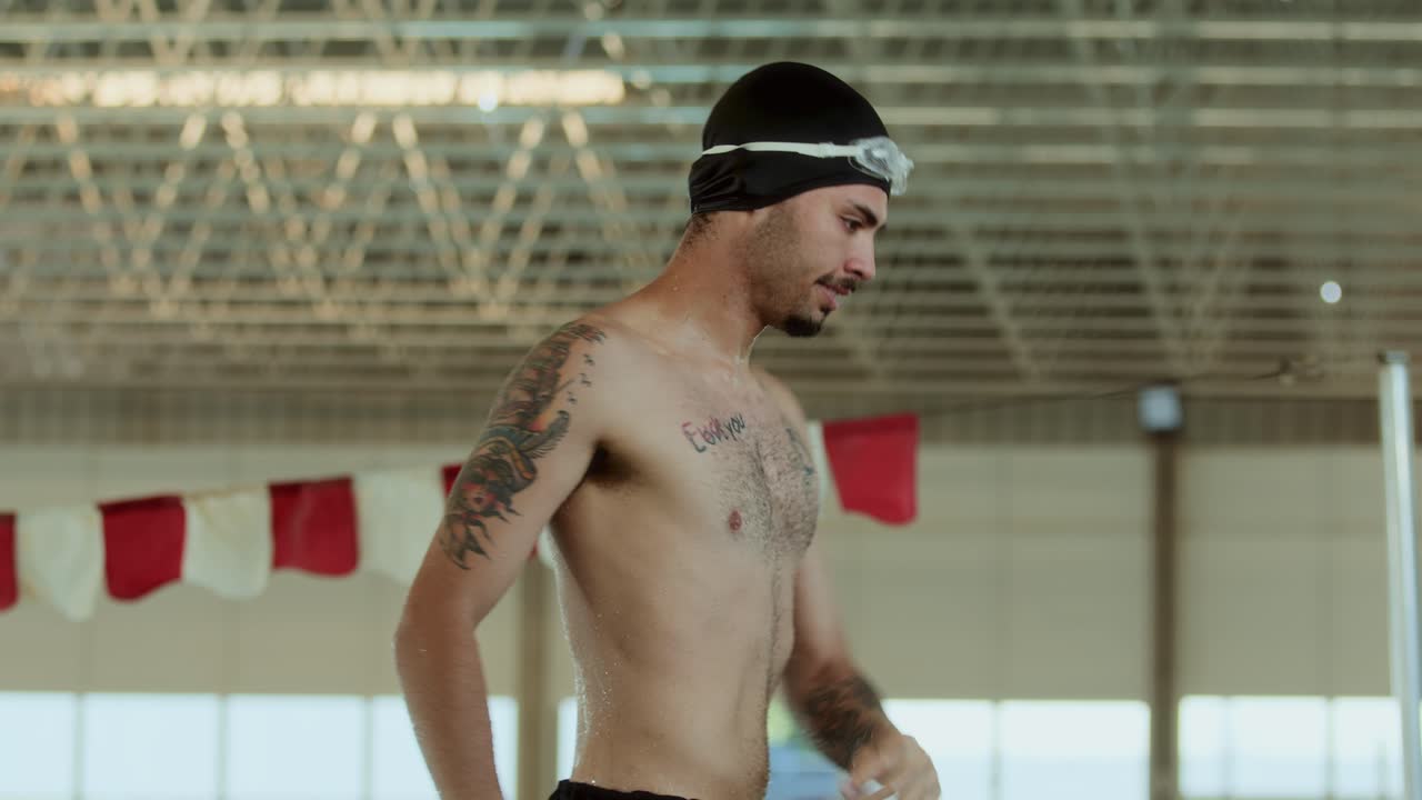 Male Swimmer Preparing for Training in an Indoor Pool