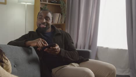 Couple-At-Home-Sitting-On-Sofa-In-Lounge-Having-Breaking-Up-Argument