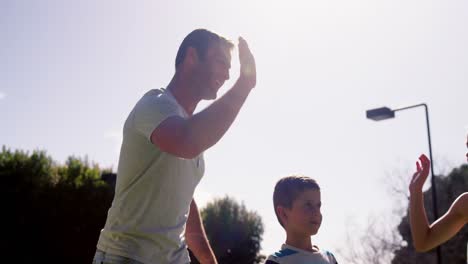 family giving high five to each other in garden