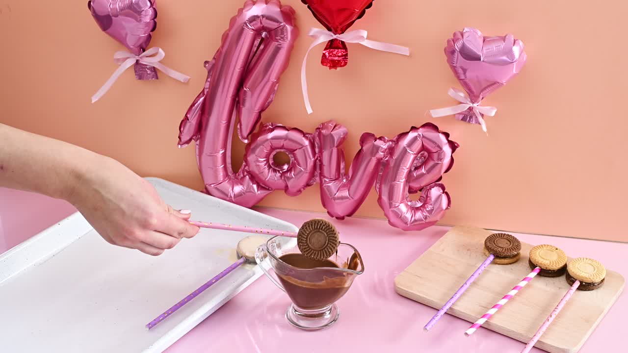 녹은 검은 초콜릿에 케이크 팝스를 담그고, 케이크 포프를 만들고, 파티를 위해 디저트를 준비합니다.