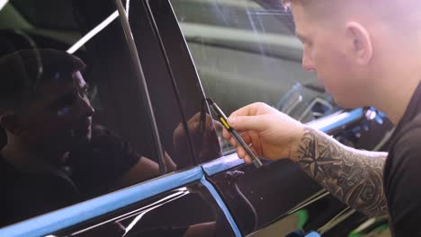 man covering car with vinyl polyurethane tape. films for the car. sticker protective film on the car