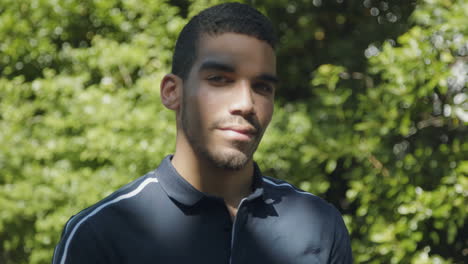 confident man standing outside, looking at camera, being serious